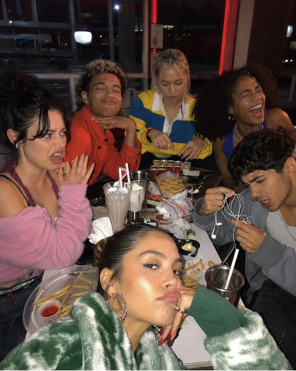 Six friends crammed into a late-night diner booth, every one of them a different mood